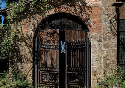Dettaglio della facciata in tufo e mattoni con rose rampicanti
