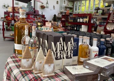 Allestimento dell’angolo enoteca e goloserie La Trinità con bottiglie, liquori e decorazioni natalizie