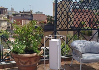Terrazza urbana con grande vaso ornamentale e arredi da esterno