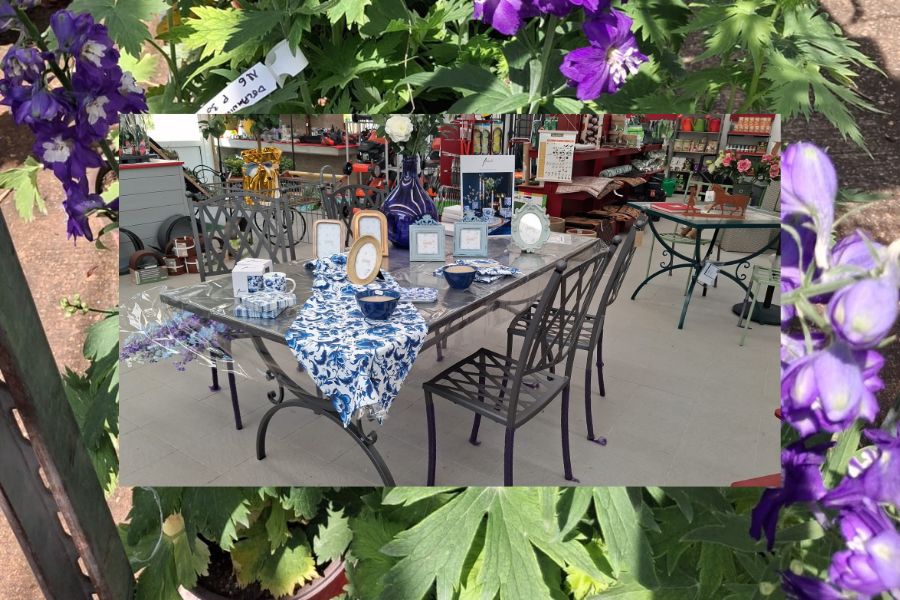 tavolo da pranzo per esterni con complementi d'arredo e decorazioni esposto al garden de la trinità, circondato da fioriture estive
