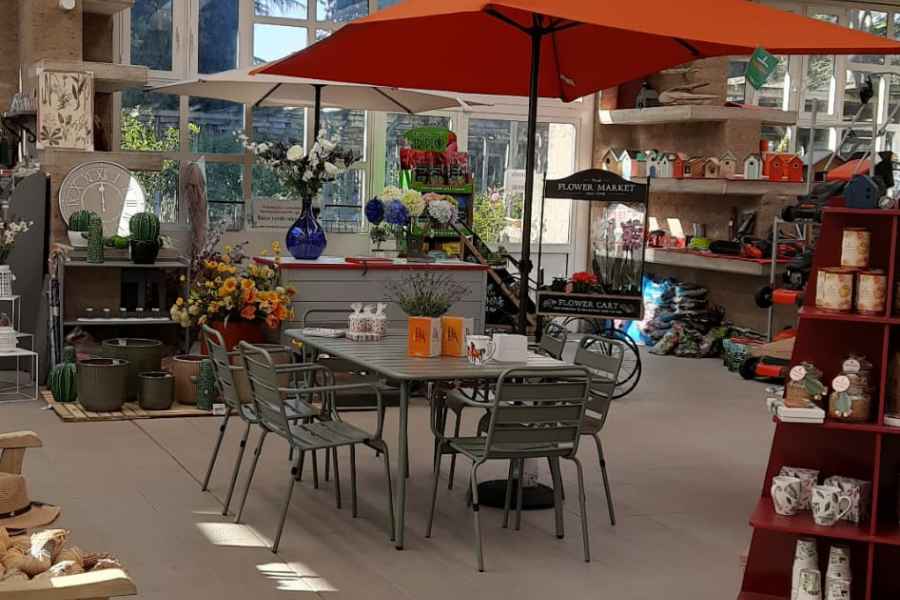 spazio del garden della trinità con ombrellone, arredi da esterno, fiori e prodotti per il giardino