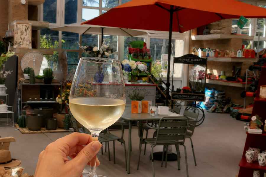calice di vino bianco in primo piano nello spazio shop del centro di giardinaggio della trinità
