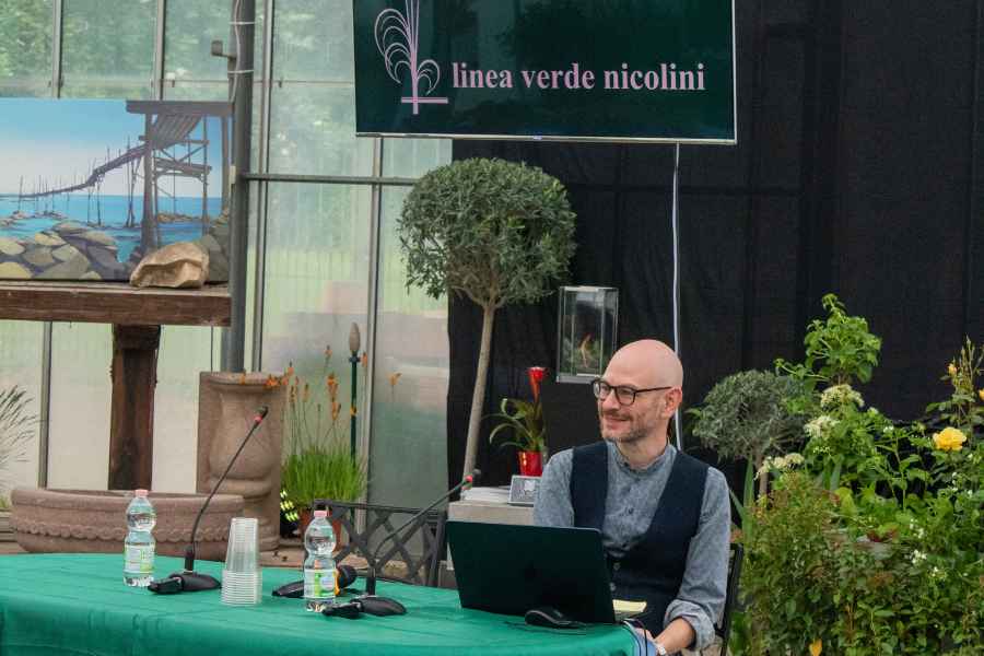 l’architetto federico bordin seduto davanti a un computer durante un incontro ala Trinità, tra piante e fiori