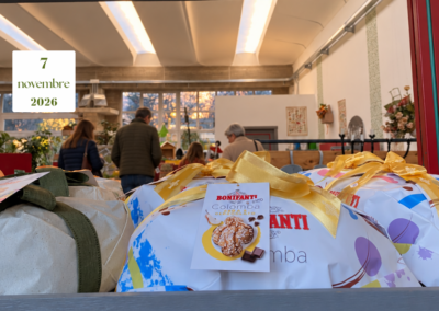 Dolci confezionati con fiocchi dorati in primo piano e persone di età diverse sullo sfondo del garden.