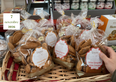 Una mano afferra una confezione di biscotti Virginia con farina integrale e miele d’acacia, tra altri sacchetti in un cesto di vimini.